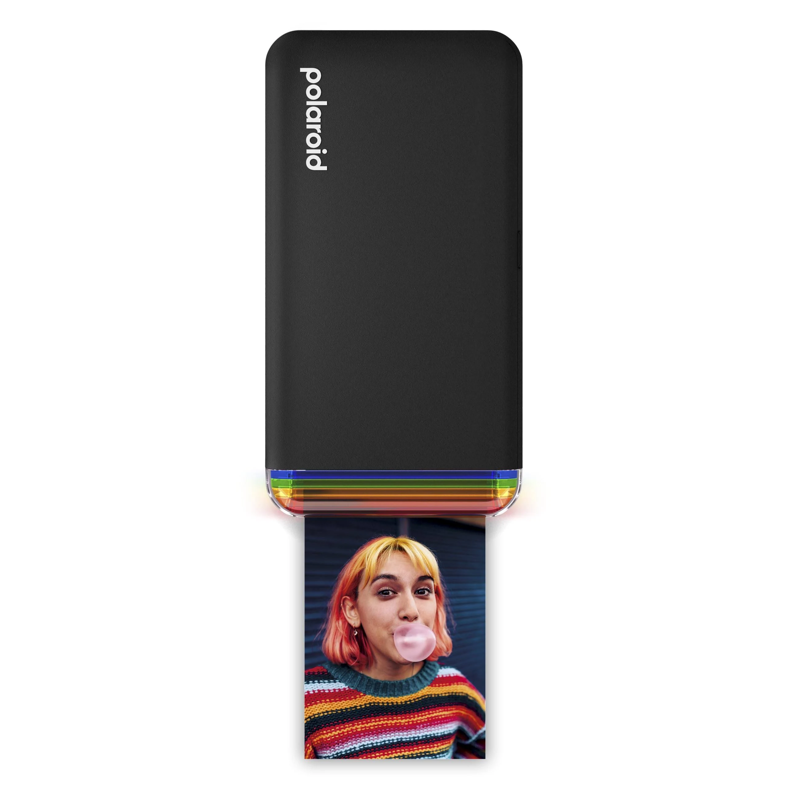 Una impresora Polaroid negra está imprimiendo una foto de una persona soplando una burbuja de chicle. La persona tiene el pelo rosa.