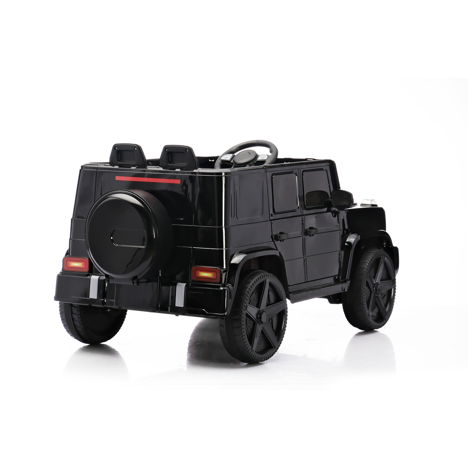 A black toy SUV is on a white surface. It has a spare tire and two seats in the back. The wheels are black.