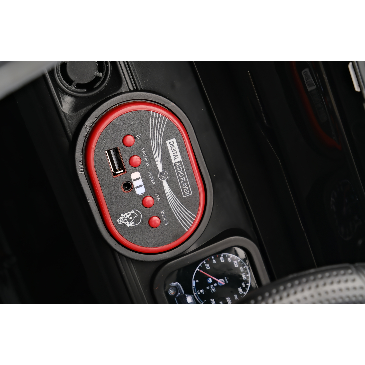 Close-up of a car dashboard with a digital audio player, USB port, and speedometer. Buttons for music and playback are visible.