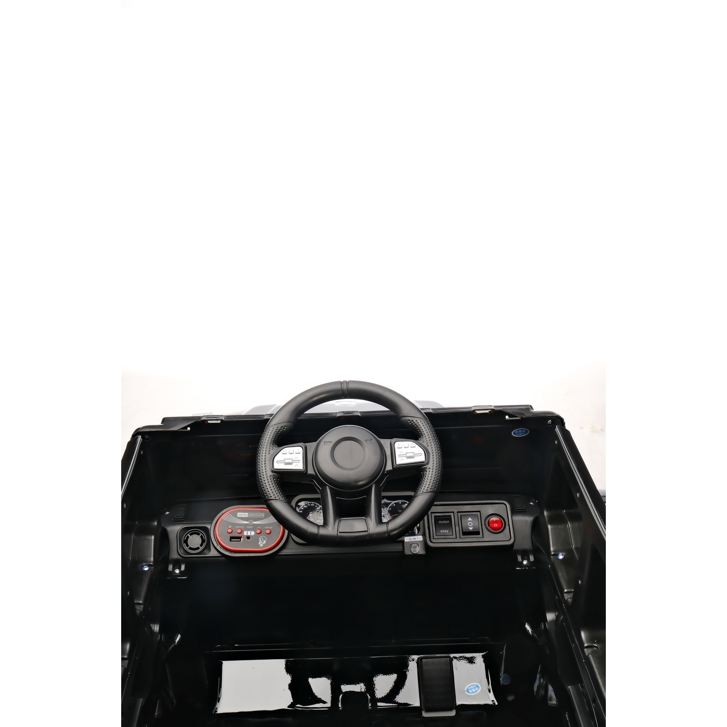 Black toy car interior. Steering wheel, dashboard with buttons, and foot pedals are visible. White background.