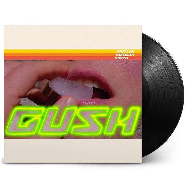 Albumcover mit Mund, der Eis hält. Der Albumname ist 'GUSH'. Rechts ist eine Schallplatte.
