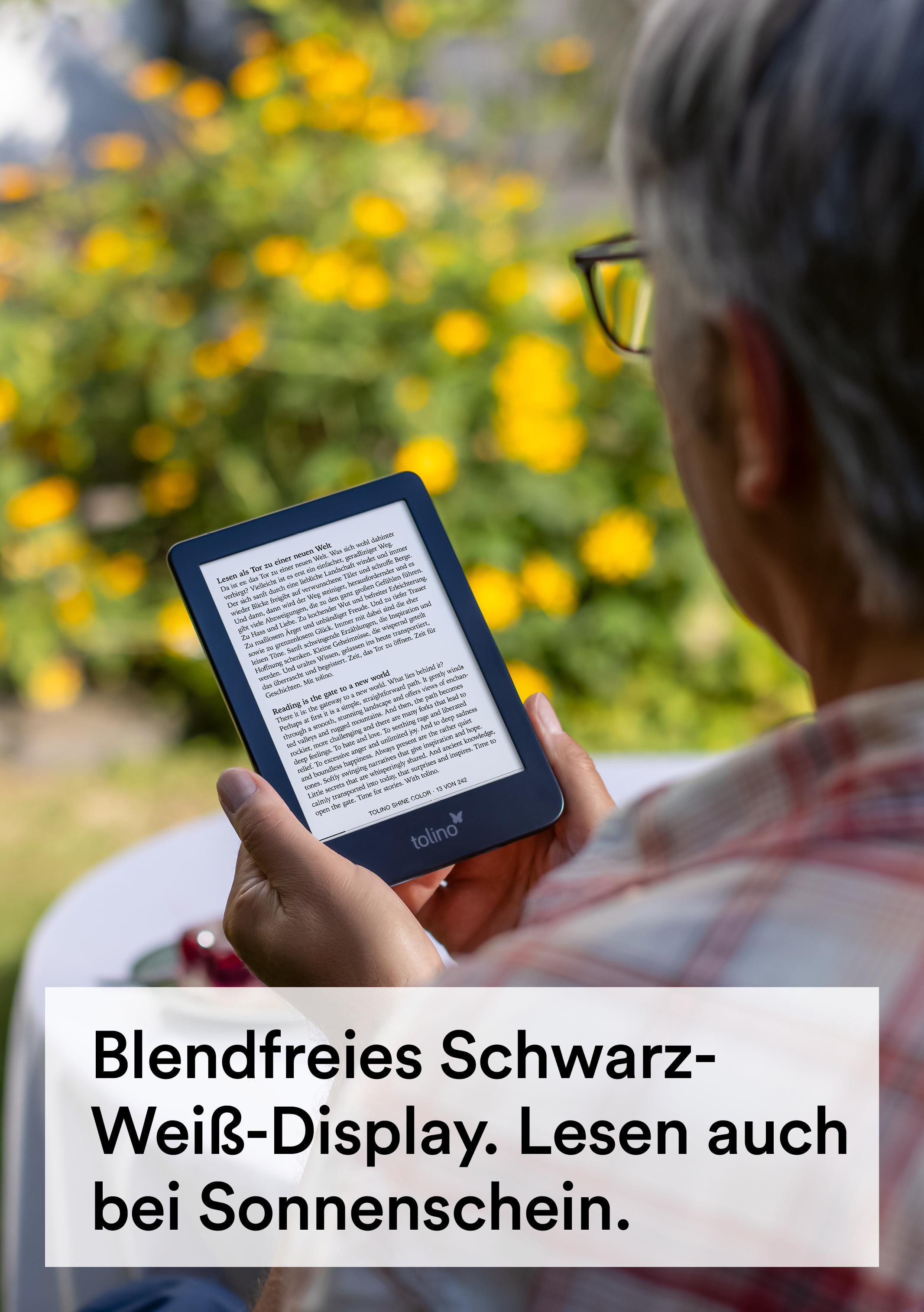 Person hält einen E-Reader im Freien, mit verschwommenem Hintergrund aus gelben Blumen.