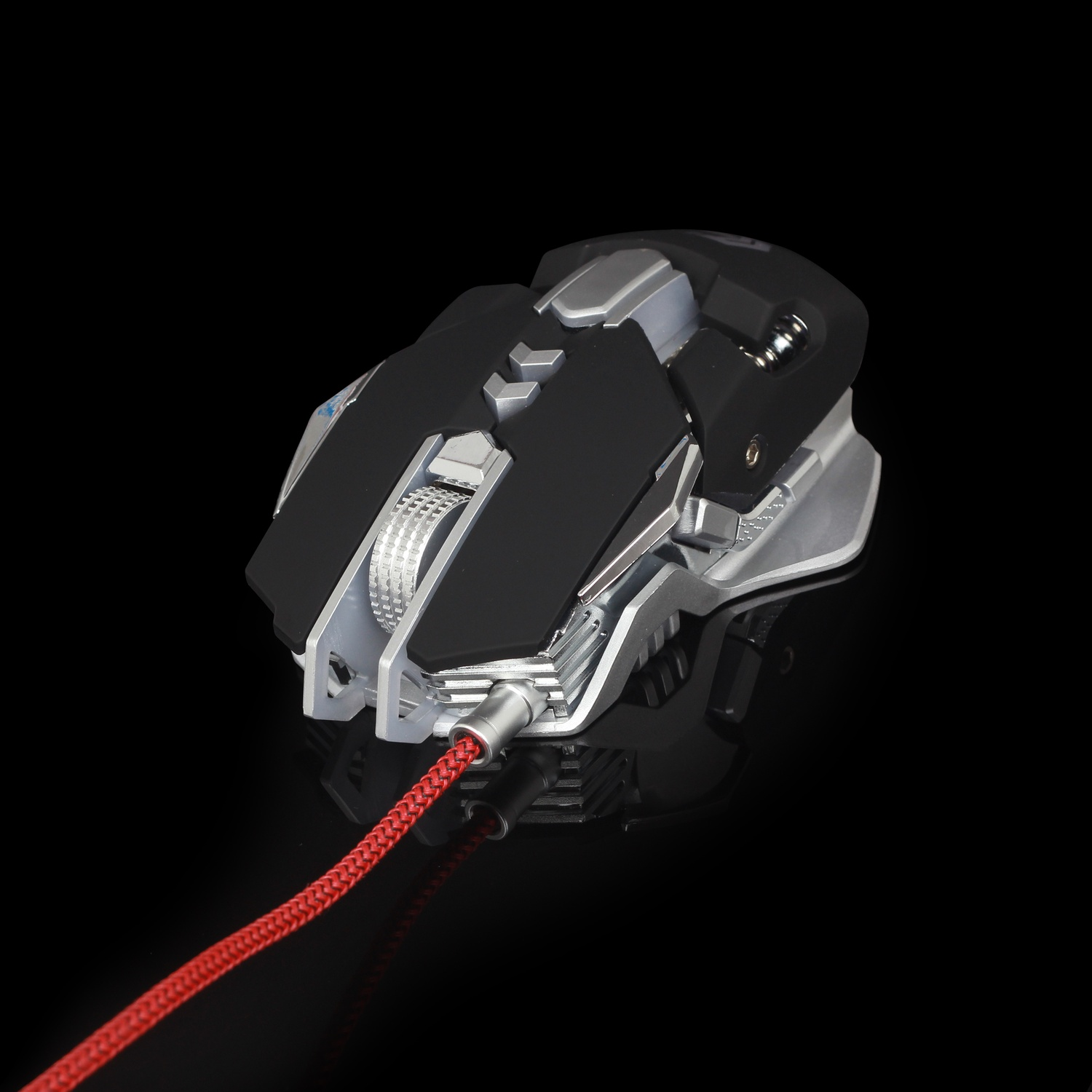 Un mouse da gioco nero e argento con un cavo intrecciato rosso, su una superficie nera riflettente.