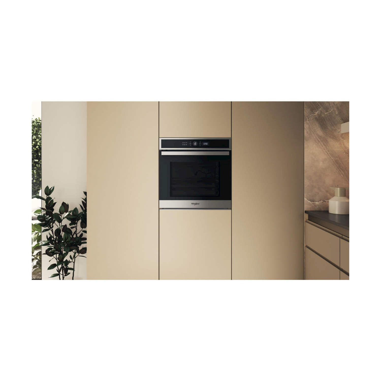 Forno a incasso in cucina. Il forno è nero con finiture in acciaio inox. Armadi beige circondano il forno.