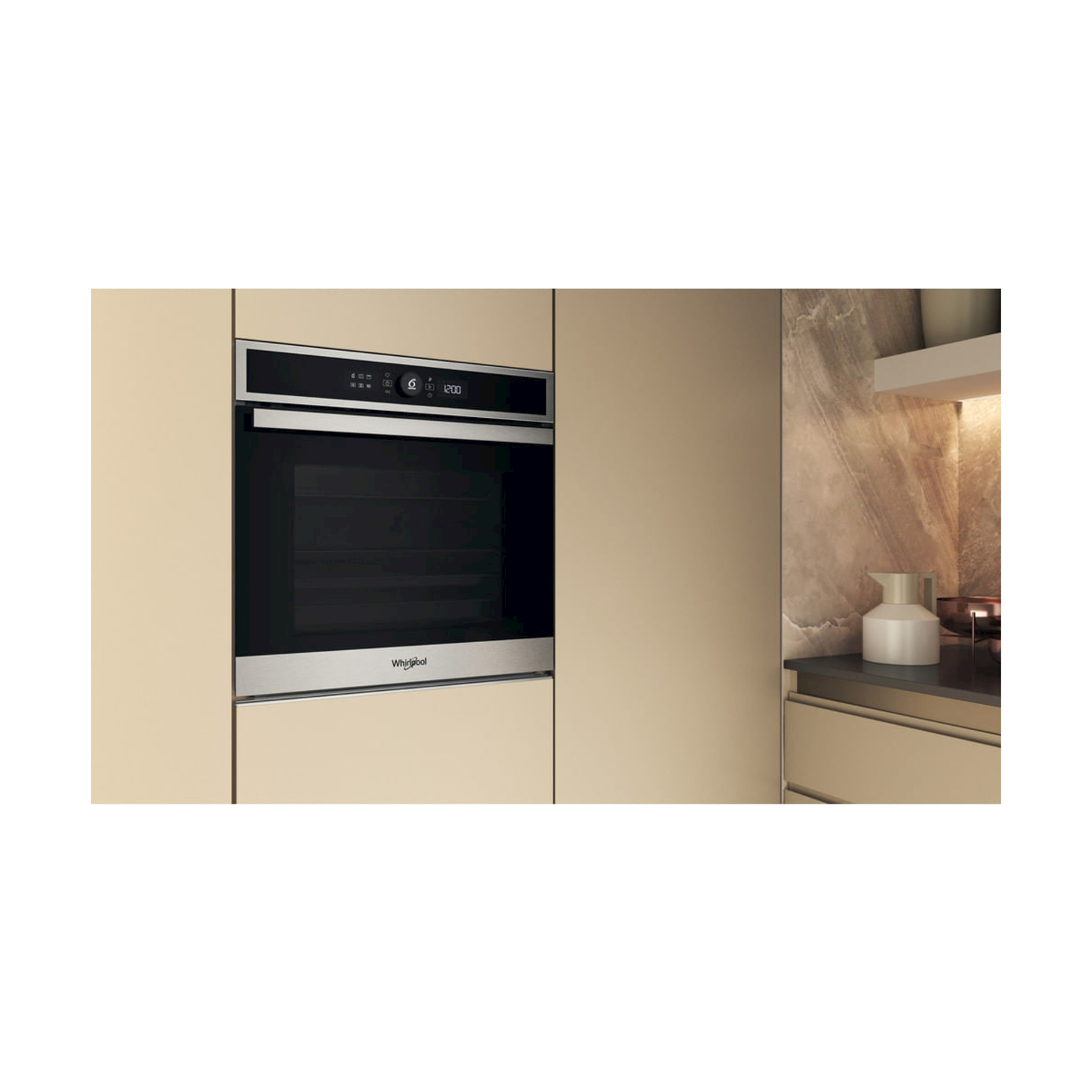 Un forno Whirlpool a incasso in una cucina beige. Un display digitale mostra l'ora. Una brocca è appoggiata sul bancone a destra.