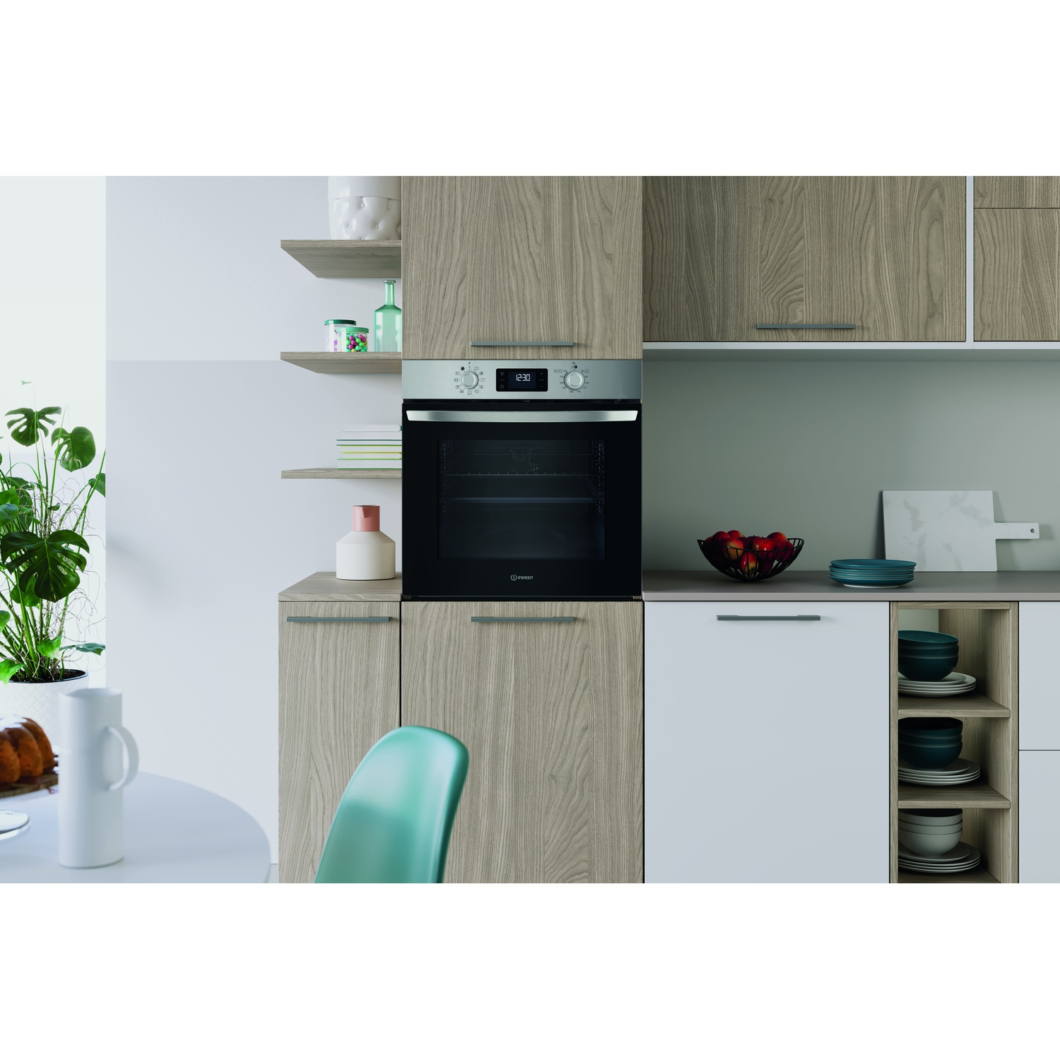 Scena di cucina con forno, mobili in legno, mensole con decorazioni e tavolo rotondo con torta e pianta. Sedia verde visibile.