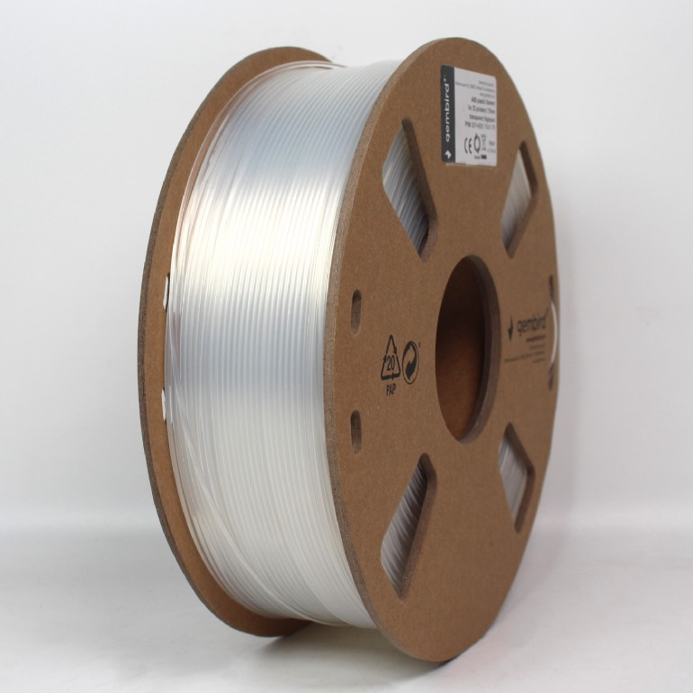Egy átlátszó filament tekercs középen. A tekercs egy kartonmaggal rendelkezik, mely köré tiszta filament van tekerve, fehér felületen.