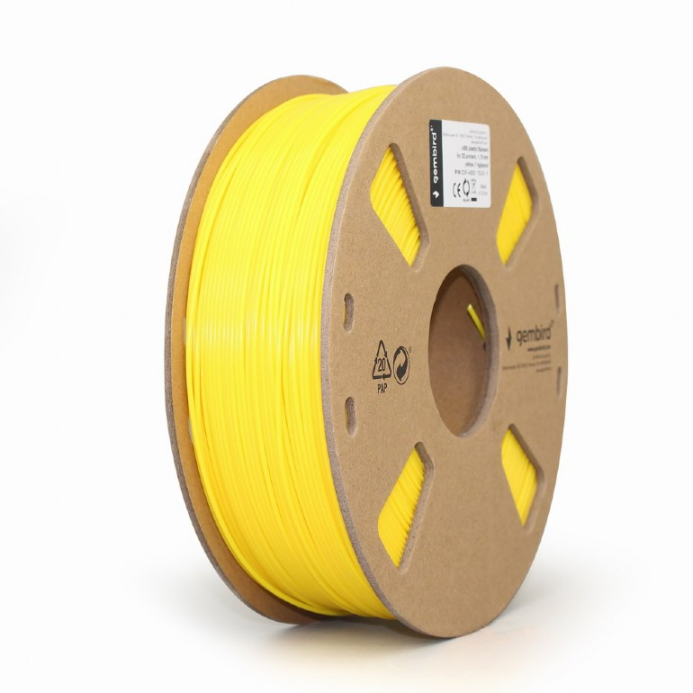 Egy sárga filament orsó 3D nyomtatáshoz fehér felületen. Az orsó sárga műanyagból és kartonból készült.