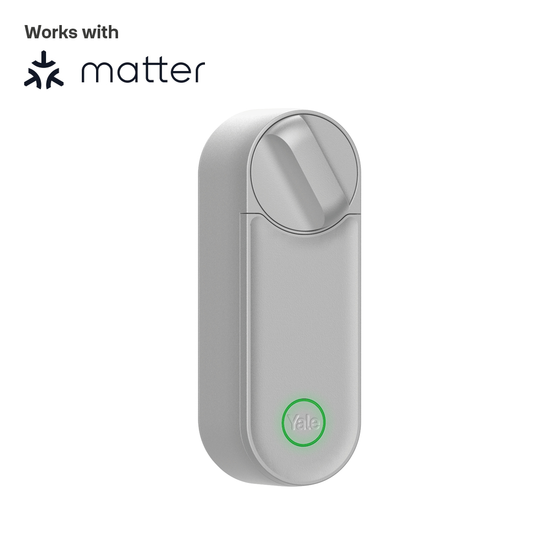 Ein hellgraues Yale Smart Lock. Das Wort 'Yale' ist sichtbar. Die Sperre befindet sich auf weißem Hintergrund. Text 'Works with matter' steht oben.
