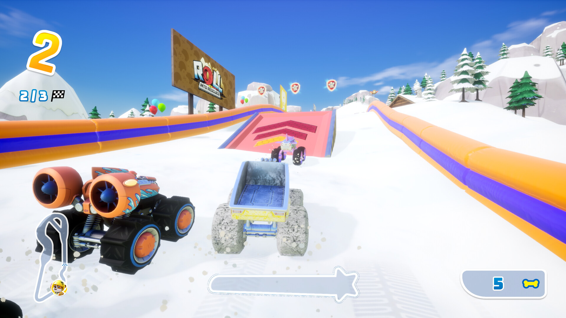 Eine Schneerennstrecke mit orangefarbenen und lila Barrieren. Zwei Monstertrucks fahren Rennen. Im Hintergrund schneebedeckte Hügel und Bäume.