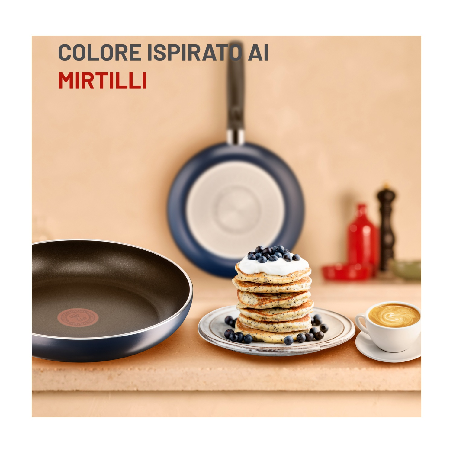 Frittelle con mirtilli e panna, caffè, padelle e testo 'COLORE ISPIRATO AI MIRTILLI'.