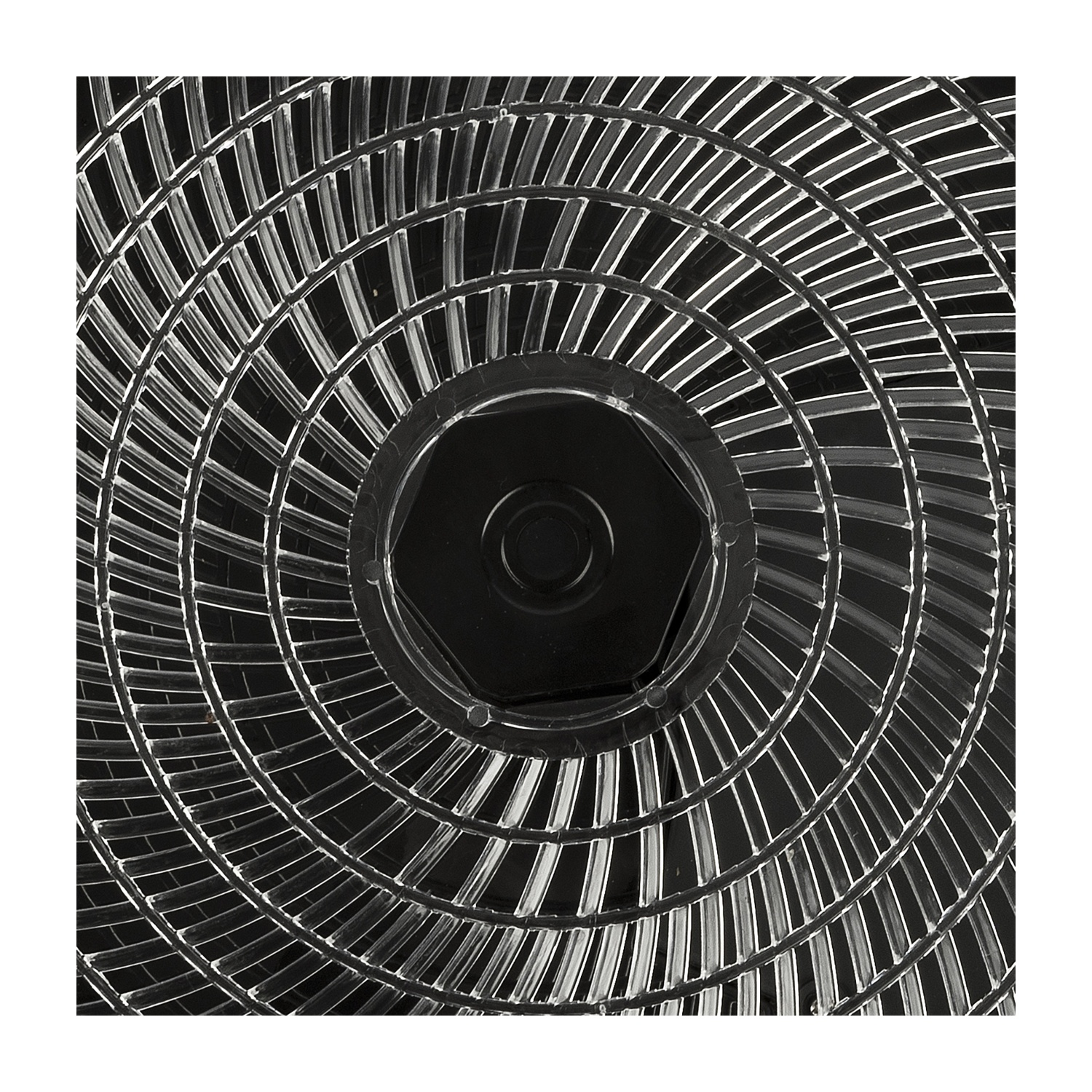 Primo piano di un ventilatore. Ha un centro nero con una serie di pale trasparenti e curve che si irradiano verso l'esterno su sfondo nero.