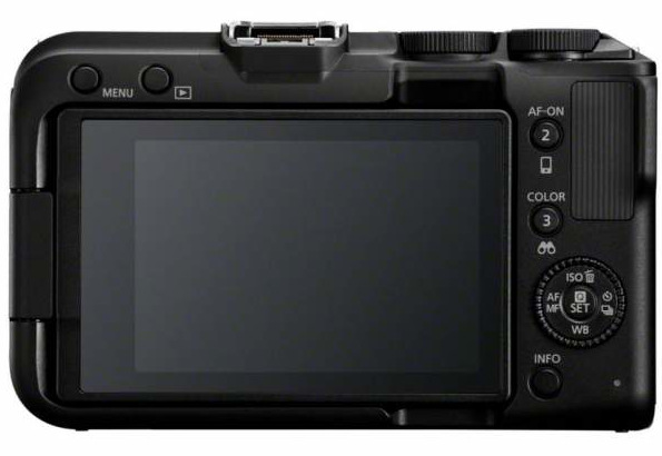 Tył czarnego aparatu. Ma ekran, przyciski i pokrętła do ustawień. Ekran jest wyłączony.