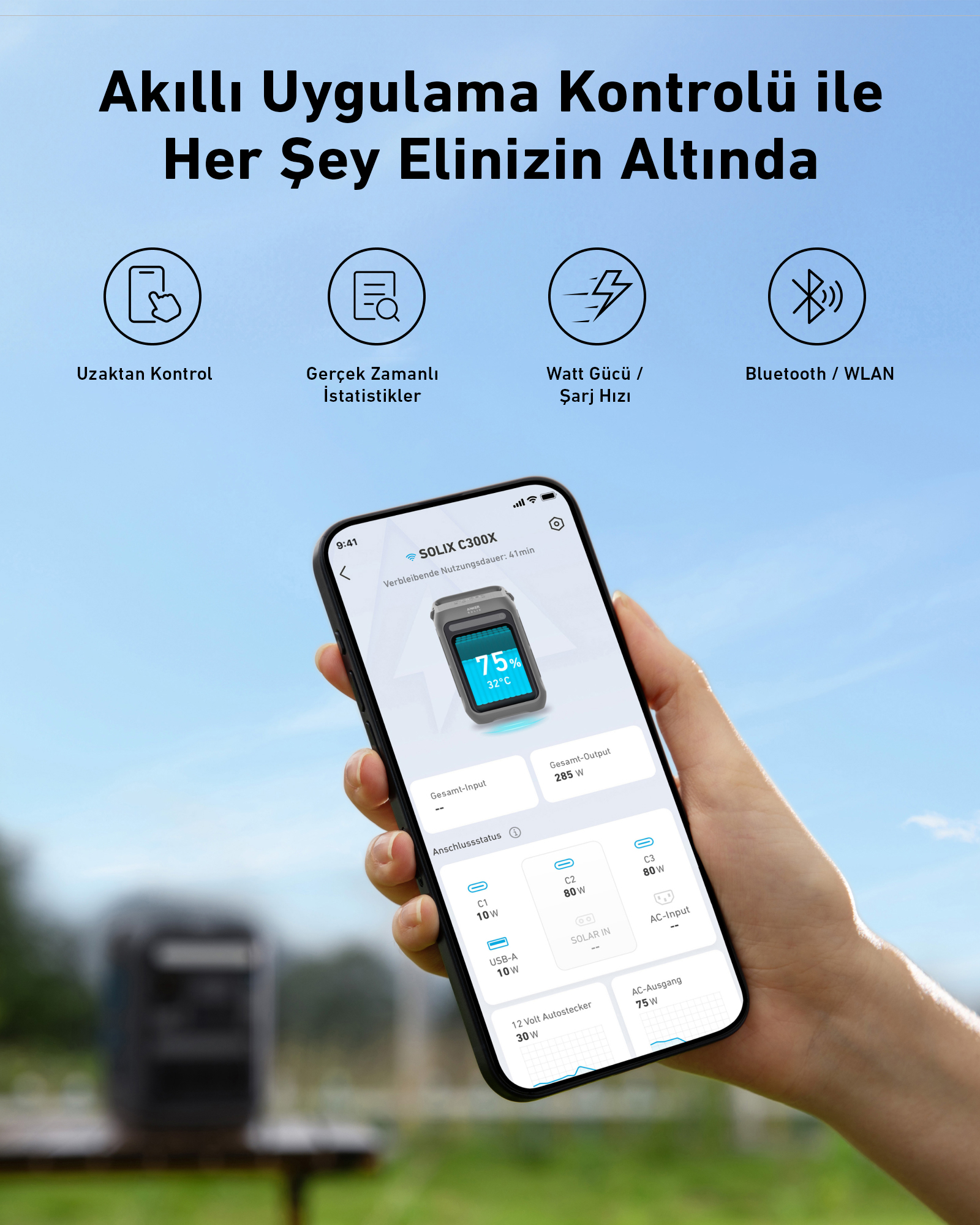 Bir el, bir cihazın durumunu ve ayarlarını gösteren bir telefon tutuyor. Arka plan bir park gösteriyor.