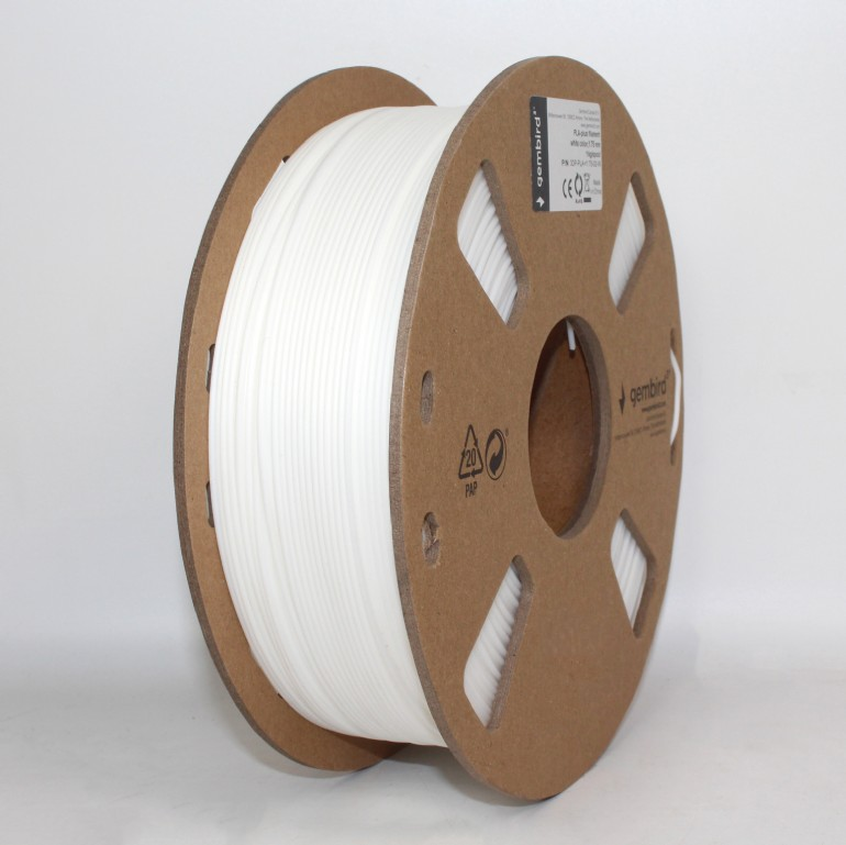 Fehér 3D nyomtató filament tekercs fehér felületen. A tekercs kartonból van, fehér filamenttel.