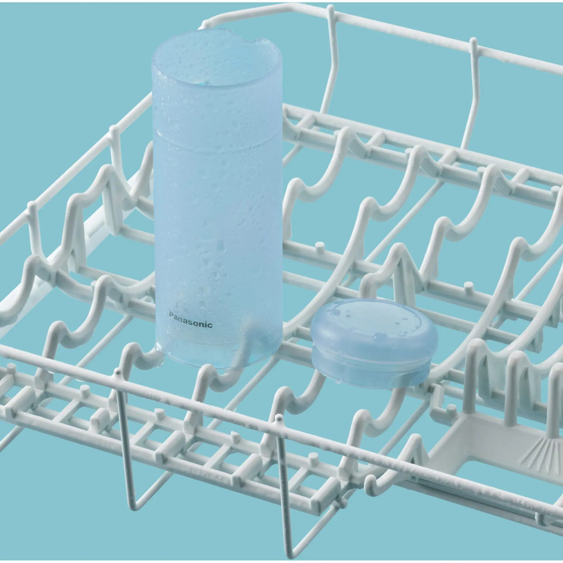 Jasnoniebieski, cylindryczny przedmiot i mała pokrywka w białym stojaku na jasnoniebieskim tle.