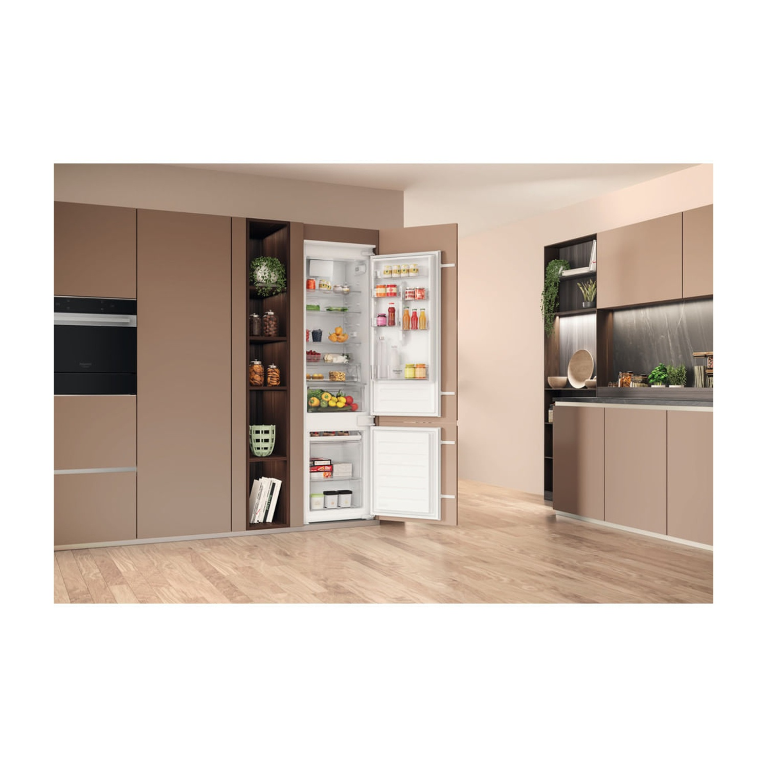 Una cucina moderna con un frigorifero aperto. Il frigorifero è pieno di cibo. Armadi e pavimenti in legno. Le piante sono visibili sullo sfondo.