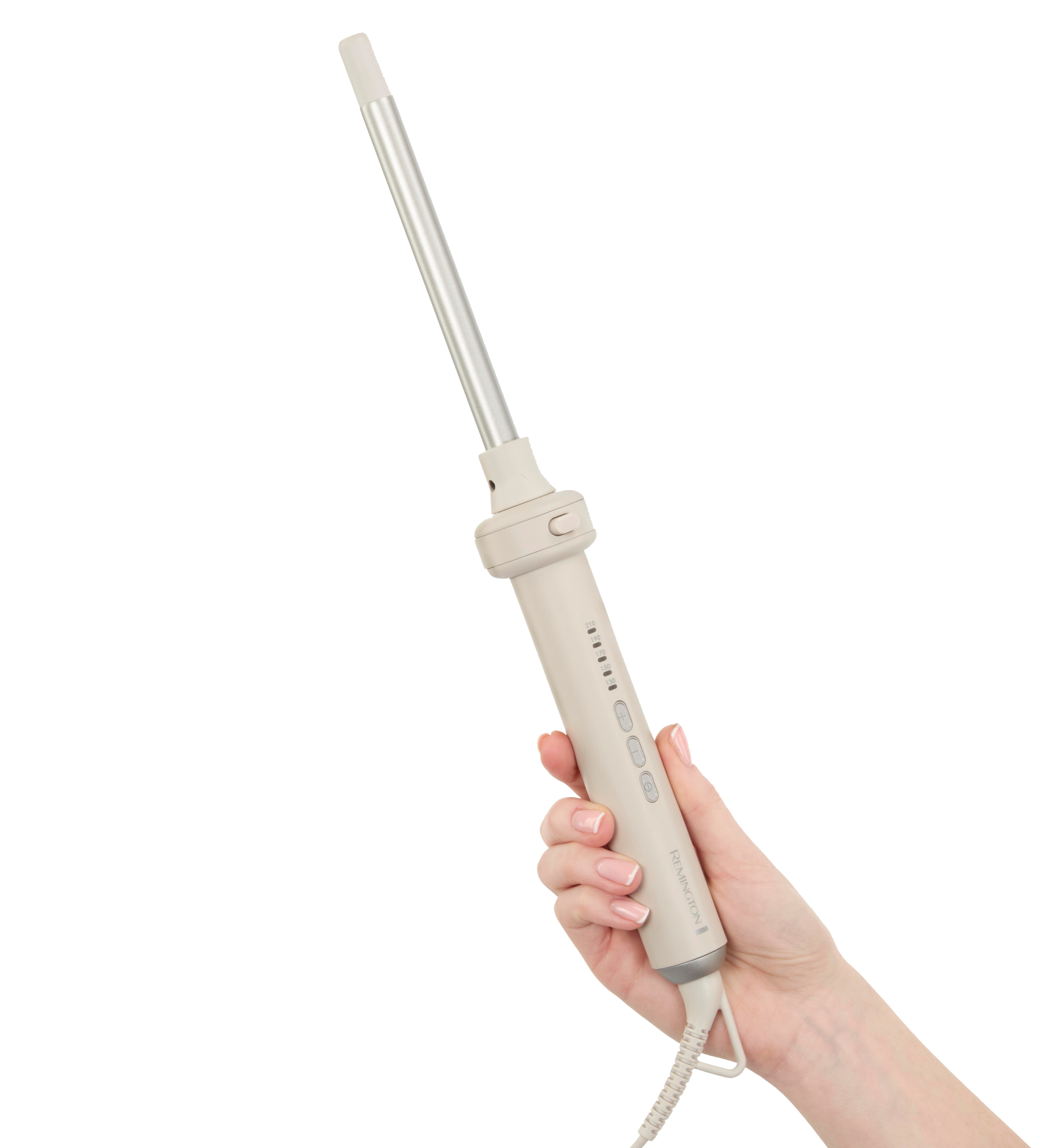Eine Hand hält einen Lockenstab vor weißem Hintergrund. Der Lockenstab ist beige und silberfarben.
