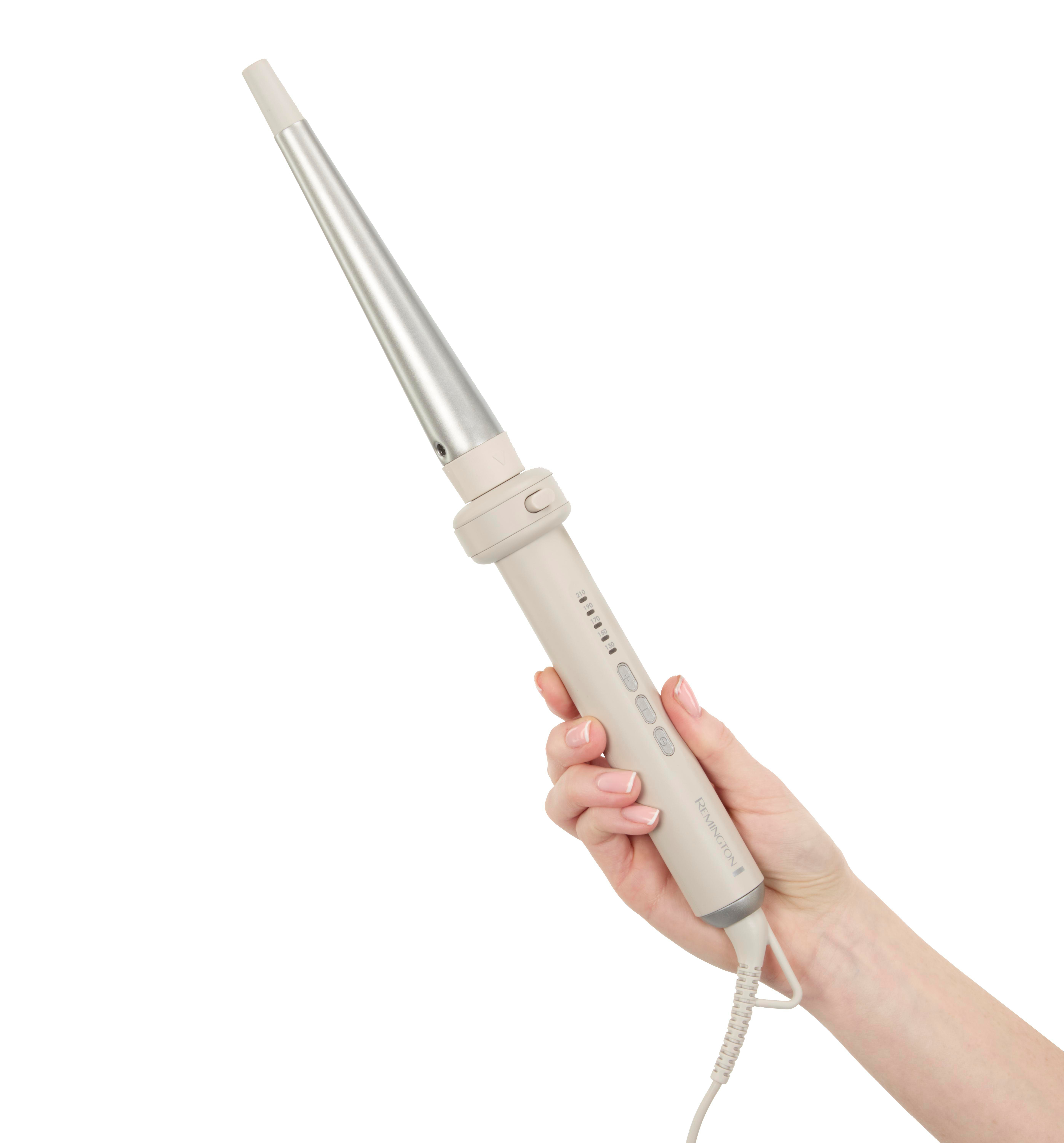 Hand hält einen Lockenstab. Es ist beige und silber. Die Hand hat einen hellen Hautton.