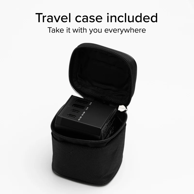 Czarne urządzenie ładujące znajduje się w czarnej walizce podróżnej, z częściowo otwartym zamkiem błyskawicznym. Tekst powyżej brzmi 'Etui podróżne w zestawie'.