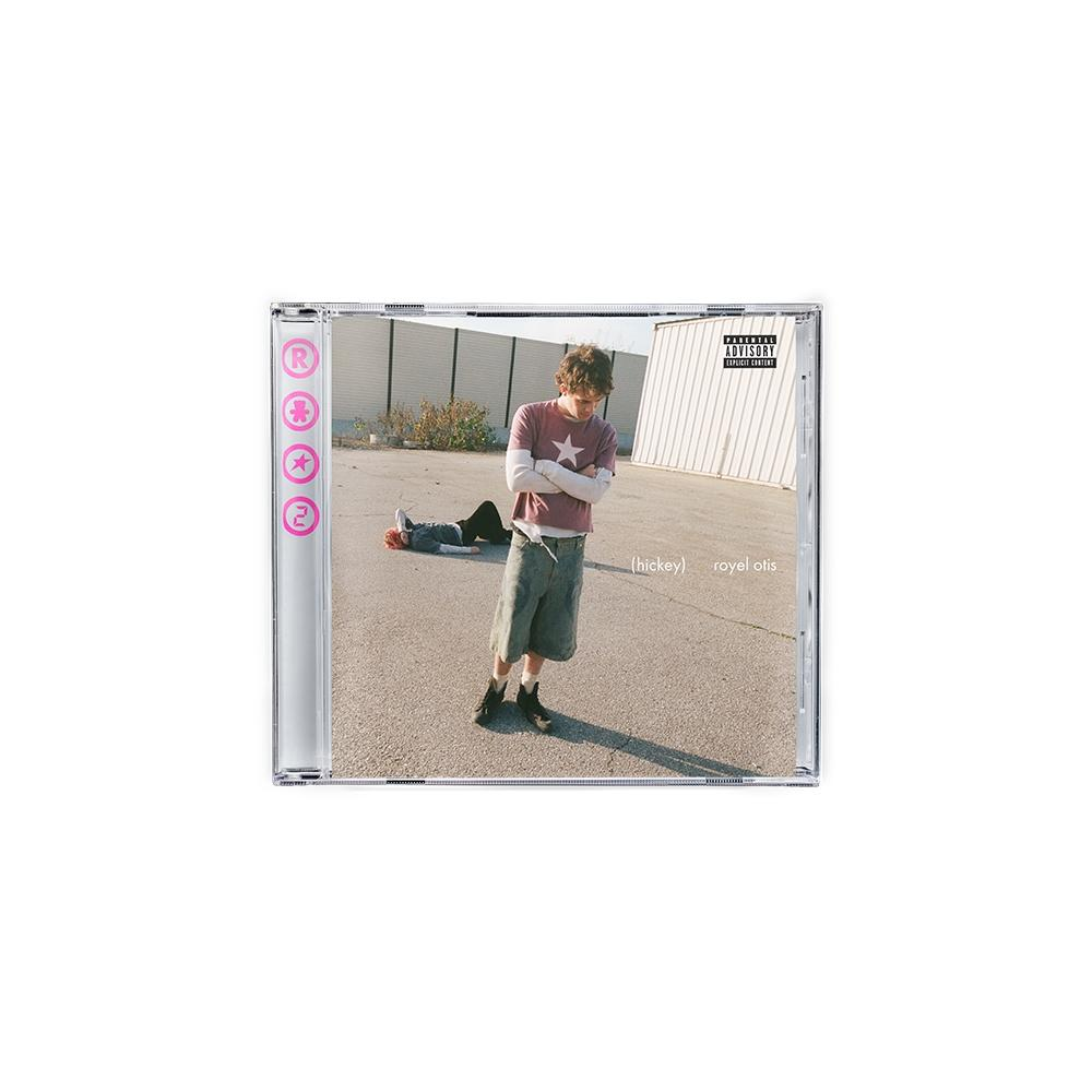 Auf dem CD-Cover steht eine Person, eine andere liegt. Die stehende Person trägt ein Sternen-T-Shirt. Im Hintergrund sind Gebäude und Pflaster.