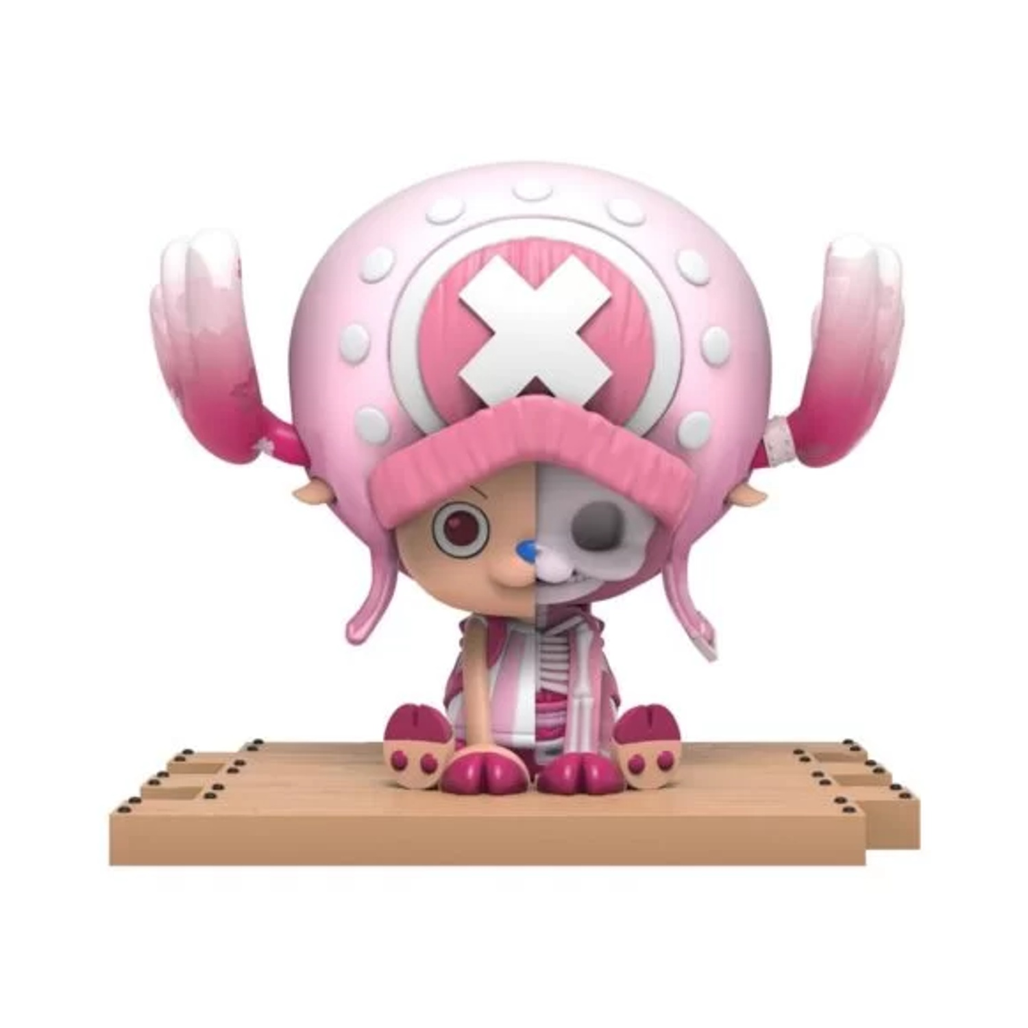 Figura di Chopper, viso diviso con anatomia parziale. Cappello rosa, orecchie e mani. Seduto su base di legno, sfondo bianco.