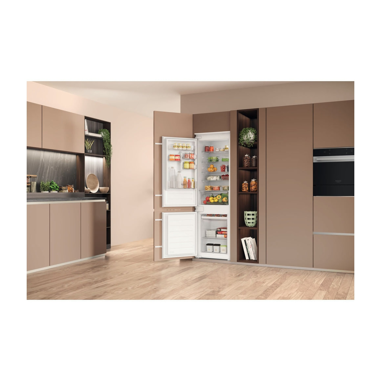 Un frigorifero con le porte aperte in una cucina moderna. Il frigorifero è pieno di cibo. Armadi e un forno sullo sfondo.