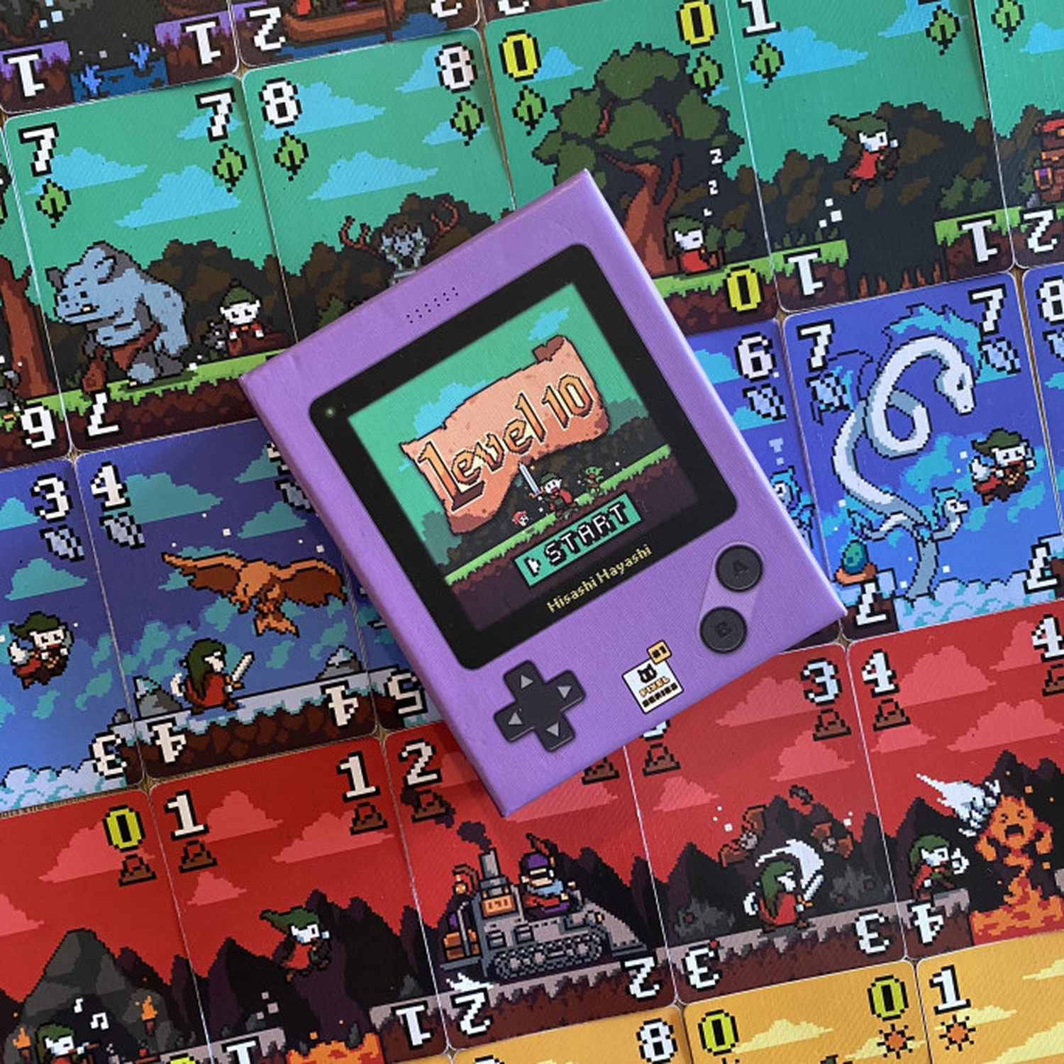 Una console di gioco viola poggia su carte pixel art. Lo schermo mostra 'Level 10'. Le carte raffigurano personaggi, mostri e numeri.