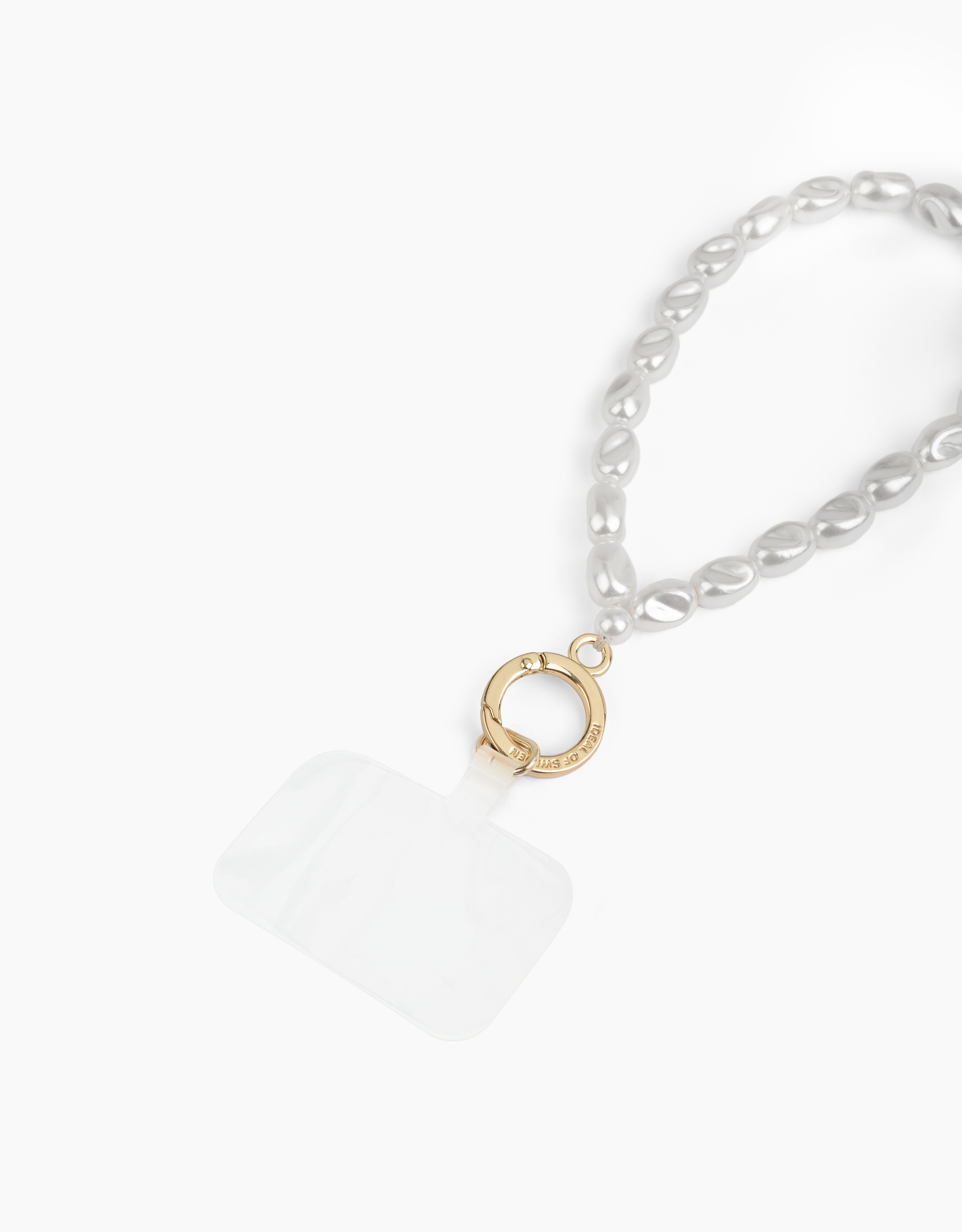Weißer Hintergrund mit einer Perlenkette und einem durchsichtigen Handyhalter mit Goldverschluss.