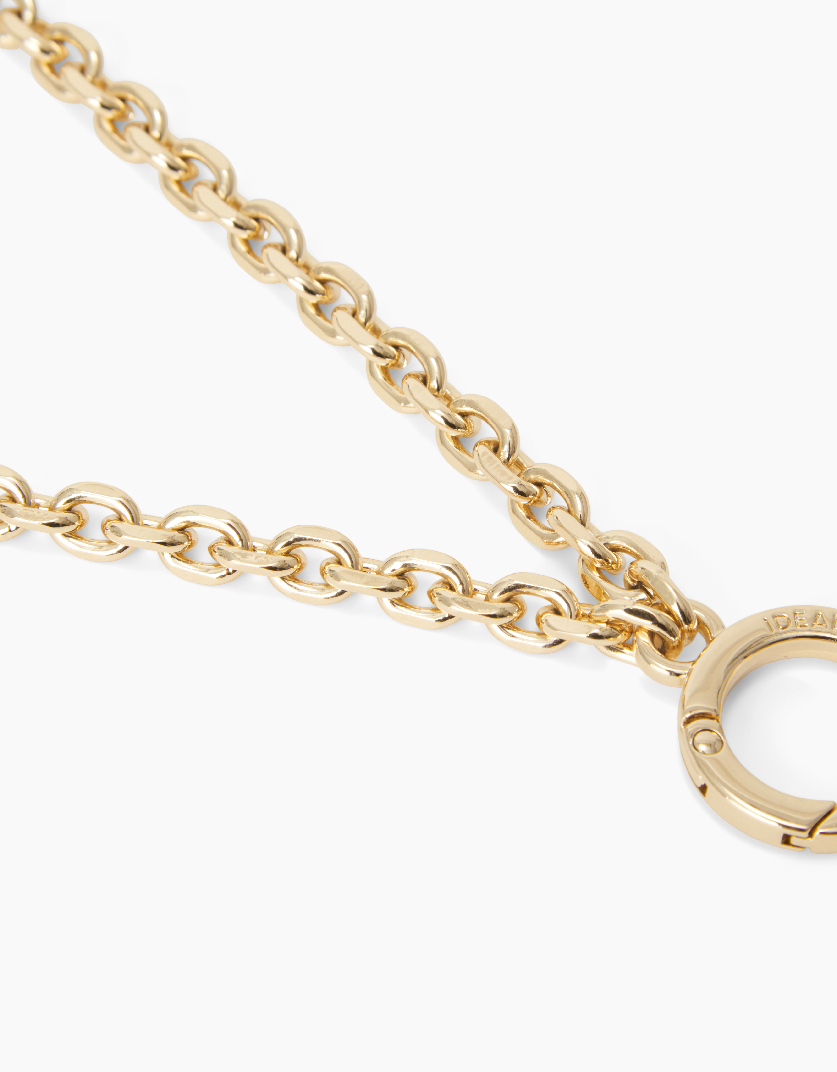 Nahaufnahme einer Goldkette mit Verschluss. Die Kette ist dick und die Glieder sind oval. Der Verschluss ist kreisförmig.