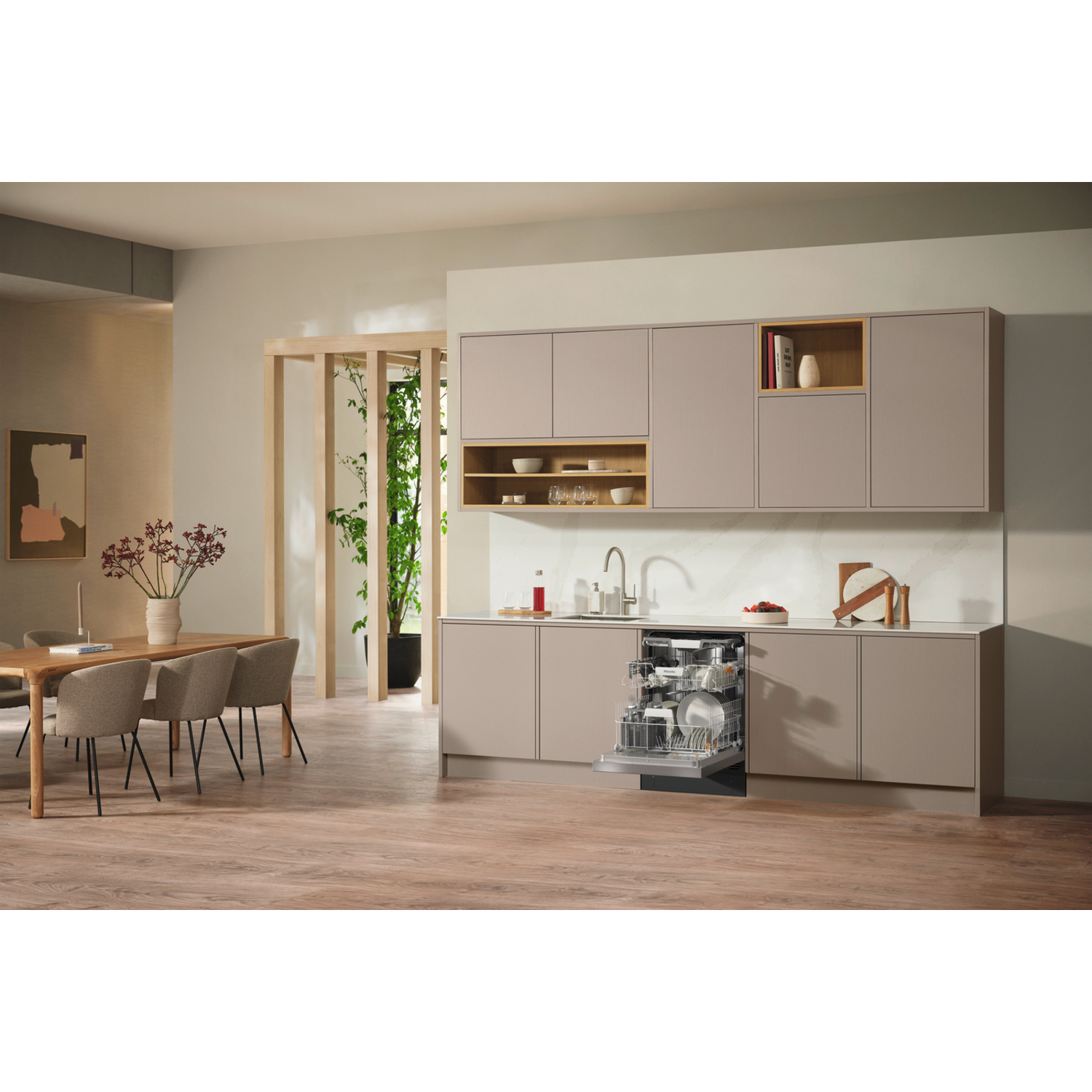 A modern kitchen with an open dishwasher, wooden floor, and a dining table with chairs. Cabinets are above a counter.