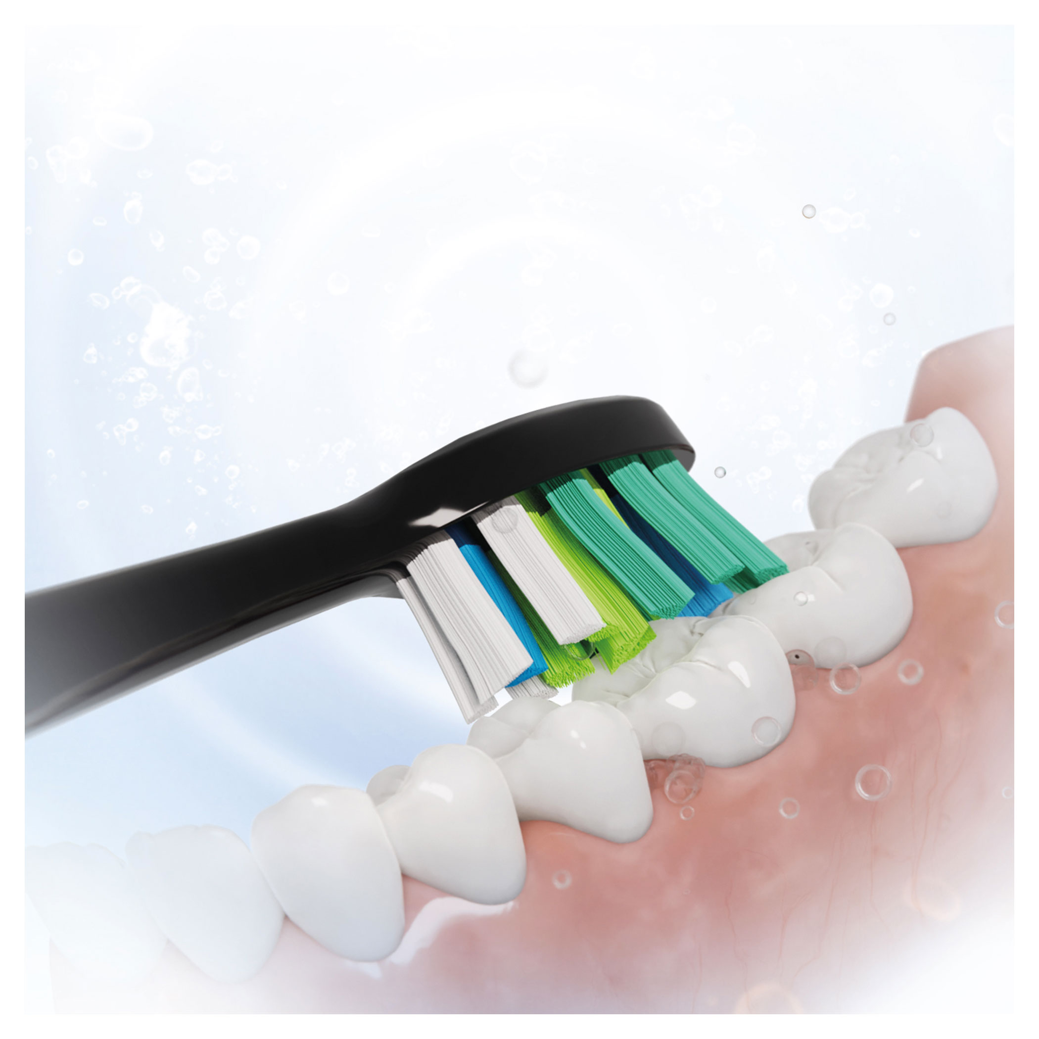 Elektryczna szczoteczka do zębów czyści zęby. Główka szczoteczki ma białe, niebieskie i zielone włosie. Białe zęby w ostrości z różowymi dziąsłami.