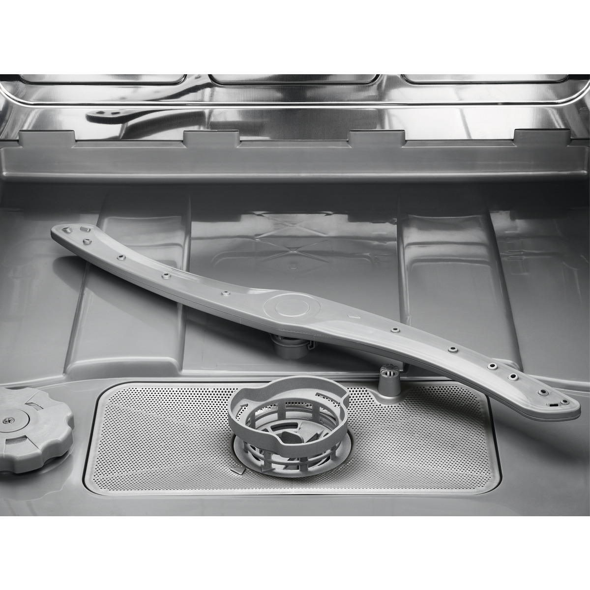 Wnętrze zmywarki. Widoczne jasnoszare ramię spryskiwacza, filtr i pokrętło. Wnętrze jest szare z metalicznym wykończeniem.