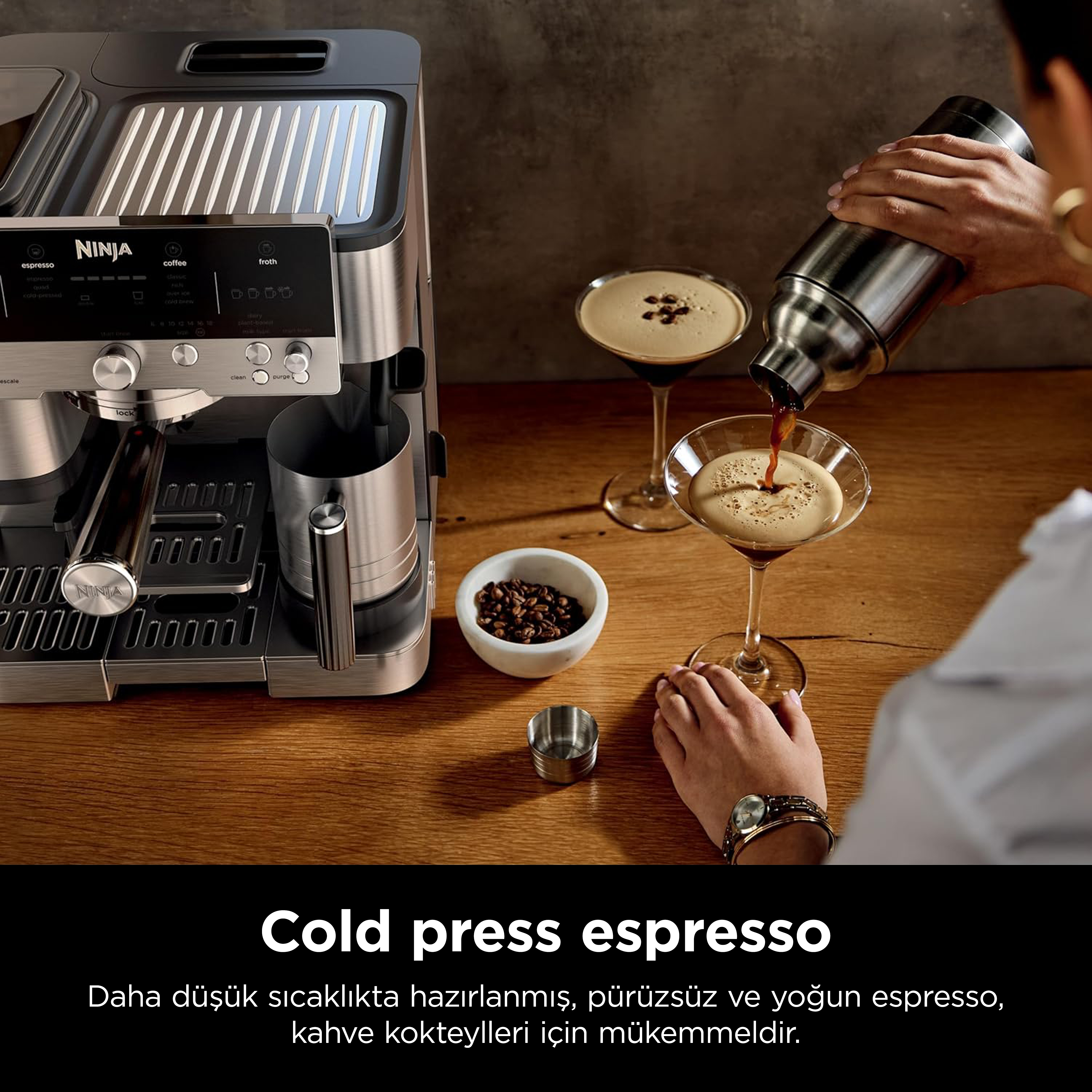 Bir kişi martini bardağına espresso döküyor. Sol tarafta bir kahve makinesi var. Bir kasede kahve çekirdekleri.