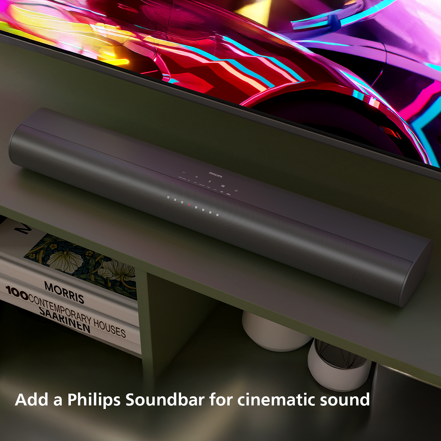 Een donkergrijze Philips soundbar onder een tv. Boeken en witte vazen op een groene plank. Tekst: 'Voeg een soundbar toe'.