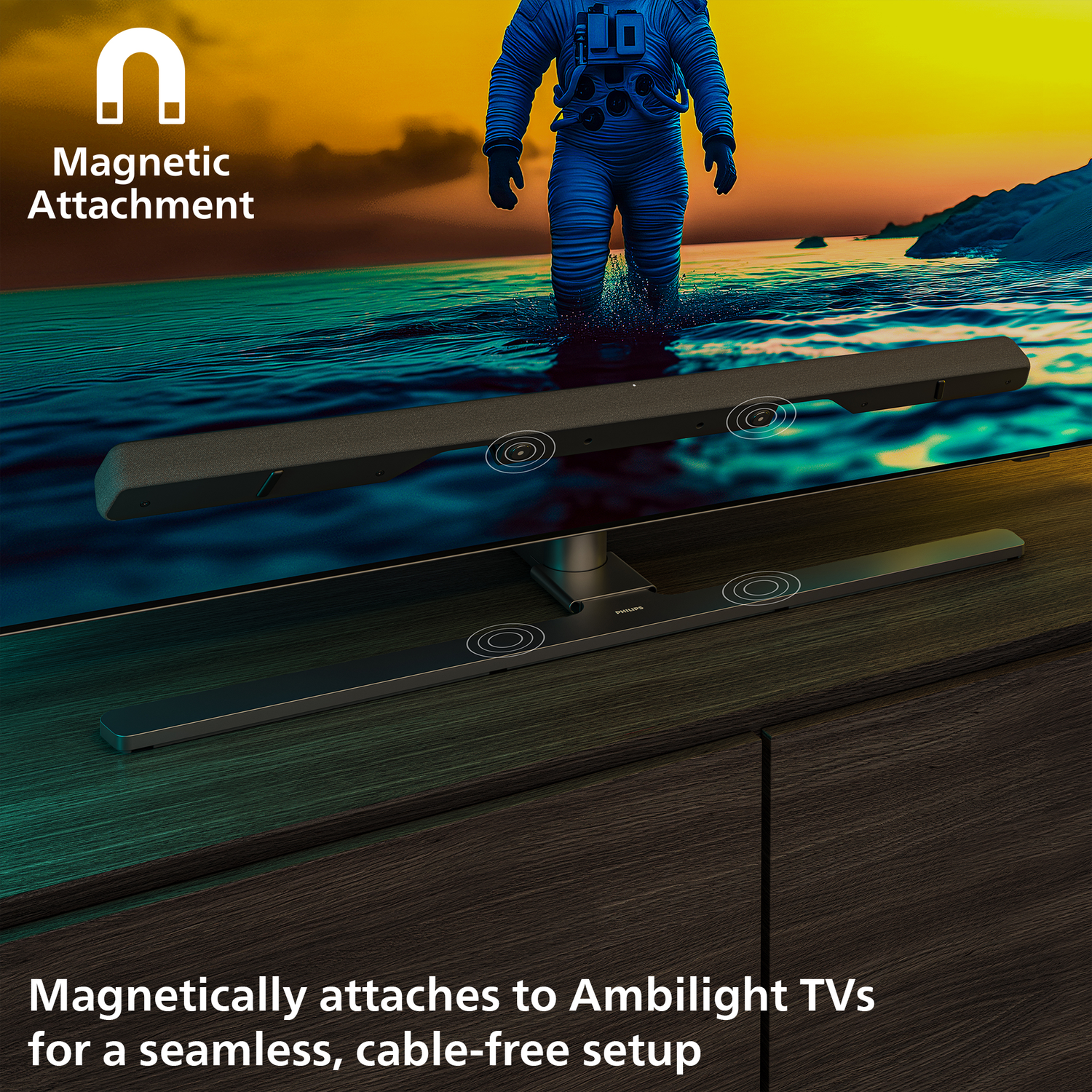 A TV with a soundbar magnetically attached. An astronaut is in the background. Text reads: 'Magnetically attaches to Ambilight TVs for a seamless setup'.