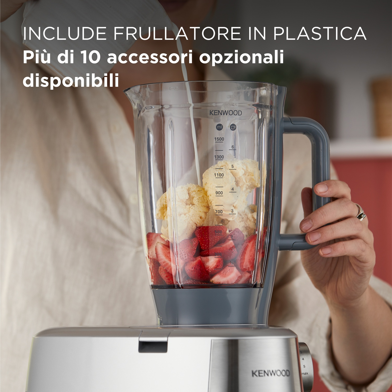 Un frullatore con fragole, gelato e liquido che viene versato. Il frullatore è su una base argentata.