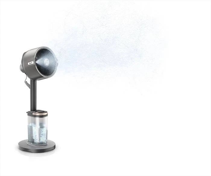 Un ventilador nebulizador gris Shark rocía niebla. Tiene un depósito de agua en la base, un soporte y un cabezal de ventilador redondo.