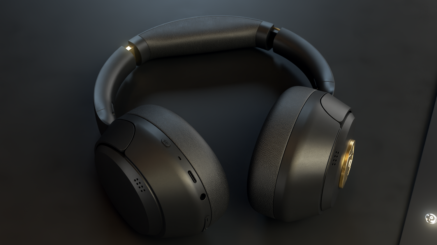 Auriculares negros sobre una superficie negra. Los auriculares tienen un acento dorado y están orientados al espectador.