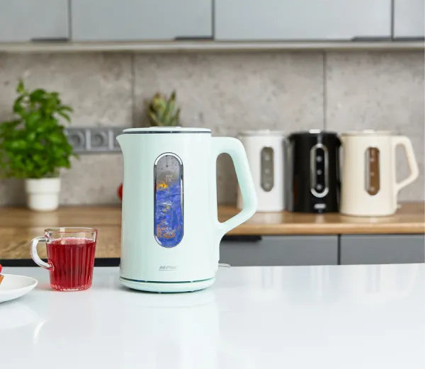 Jasnoniebieski czajnik elektryczny stoi na białej powierzchni z filiżanką czerwonego płynu. W tle stoją trzy czajniki.