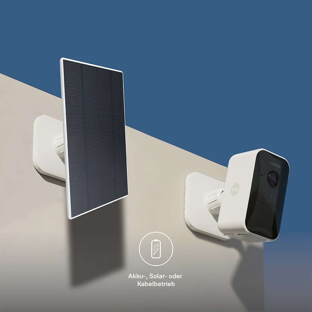 Eine weiße Überwachungskamera und ein Solarpanel sind an einer Wand montiert. Die Kamera ist schwarz-weiß, das Panel schwarz. Der Hintergrund ist blau.