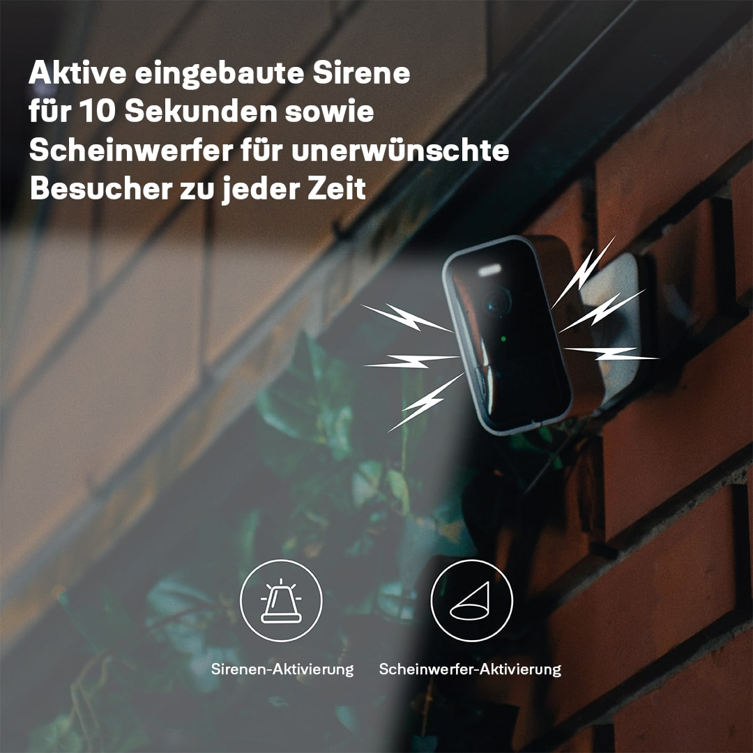 Ein schwarzes Sicherheitsgerät an einer Ziegelmauer. Text zeigt Sirenen- und Scheinwerferfunktionen. Symbole zeigen die Aktivierung.