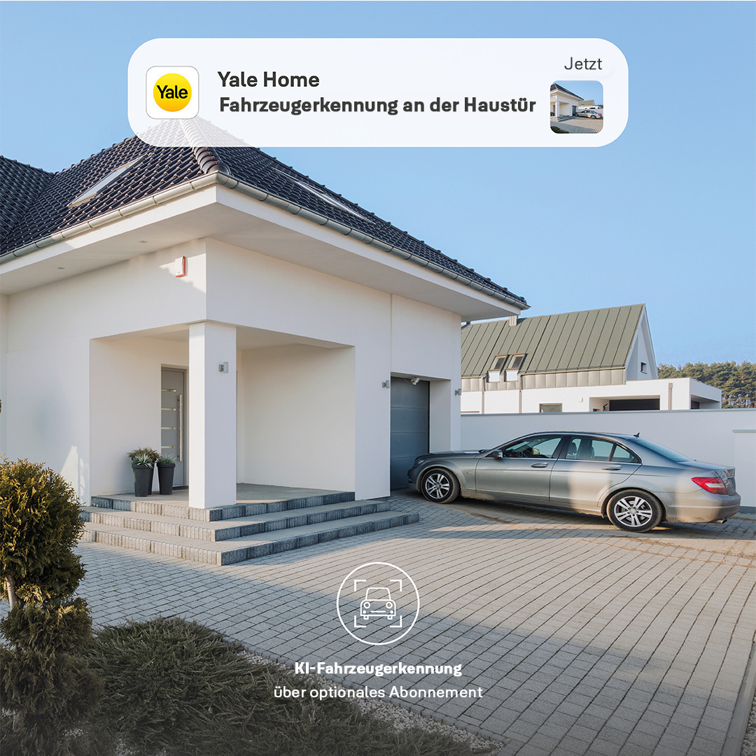 Ein modernes weißes Haus mit einem Auto in der Einfahrt. Das Yale Home Logo ist sichtbar. Text lautet 'Fahrzeugerkennung'.