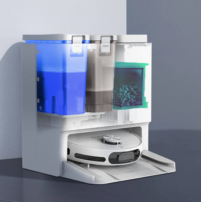 Biały robot odkurzający w stacji ładującej. Widoczny niebieski zbiornik na wodę, szary pojemnik i szczegółowa struktura wewnętrzna.