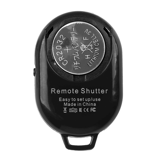 Pil bölmesi olan siyah bir uzaktan kumanda. Pil görünür durumda. Metinde 'Remote Shutter', 'Made in China' yazıyor.