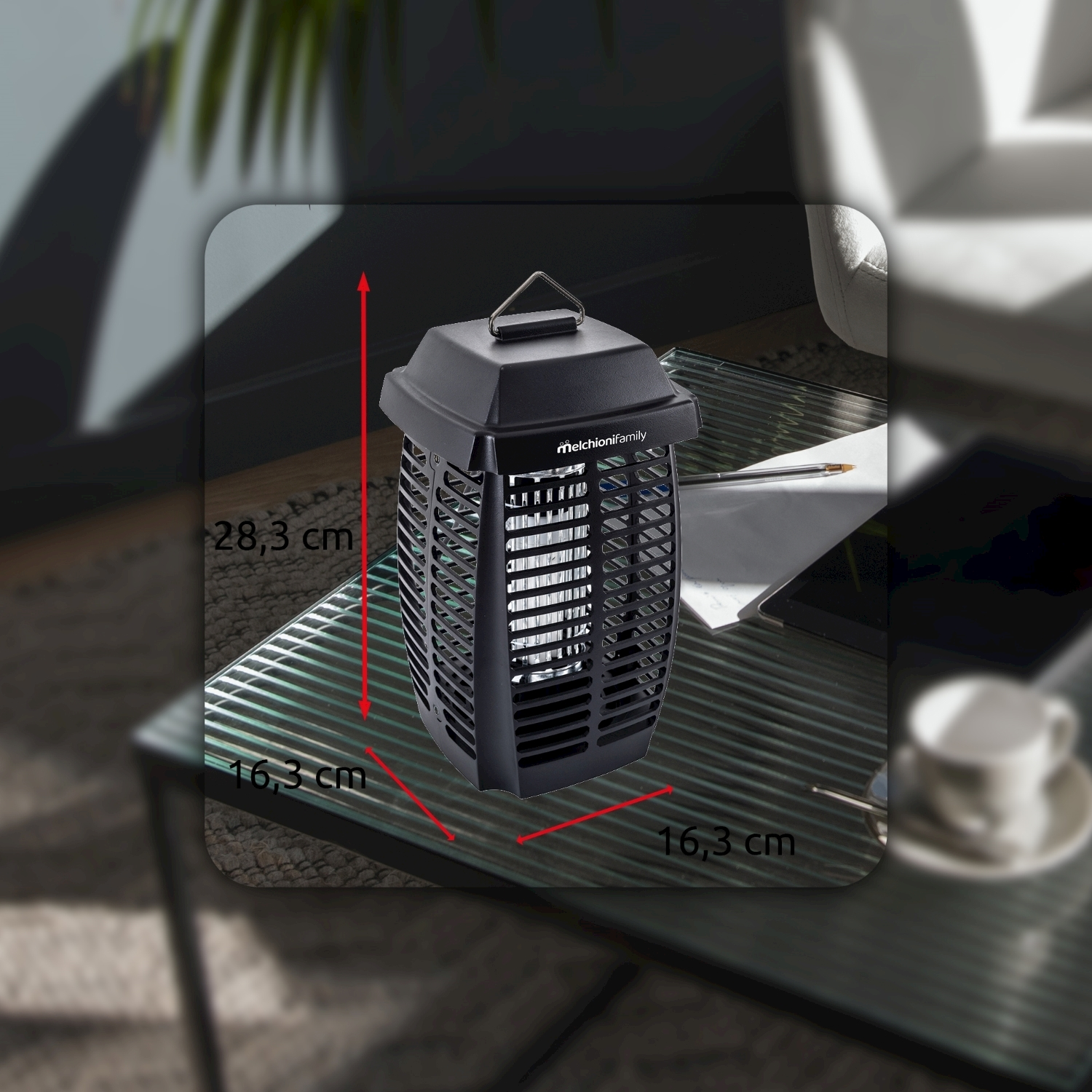 Un ammazzainsetti nero Melchioni Family è su un tavolo di vetro. Le dimensioni sono indicate. Una tazza di caffè e un tablet sono vicini.