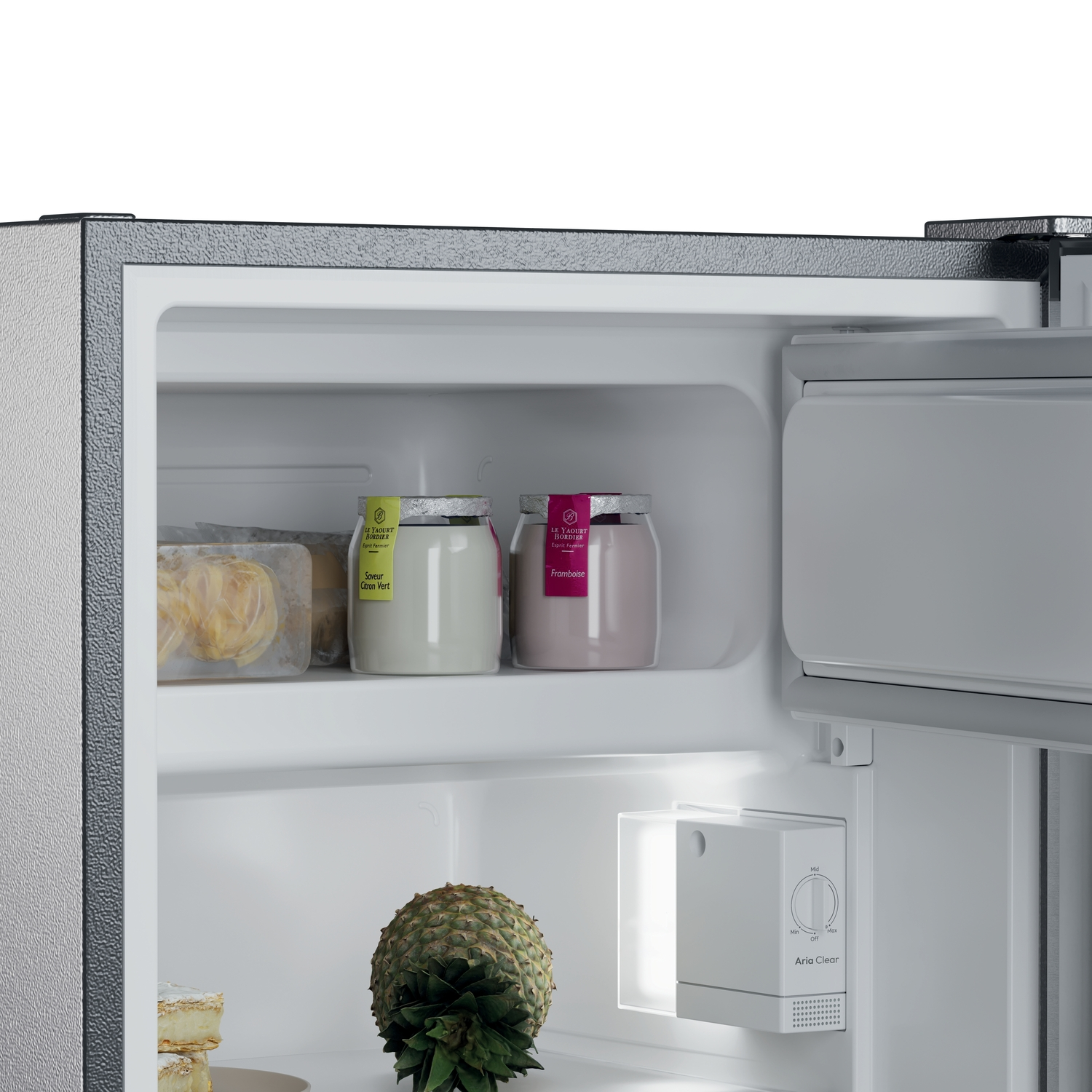 Un refrigerador abierto revela frascos de yogur, una piña y un panel de control. El interior es blanco. La puerta está ligeramente abierta.