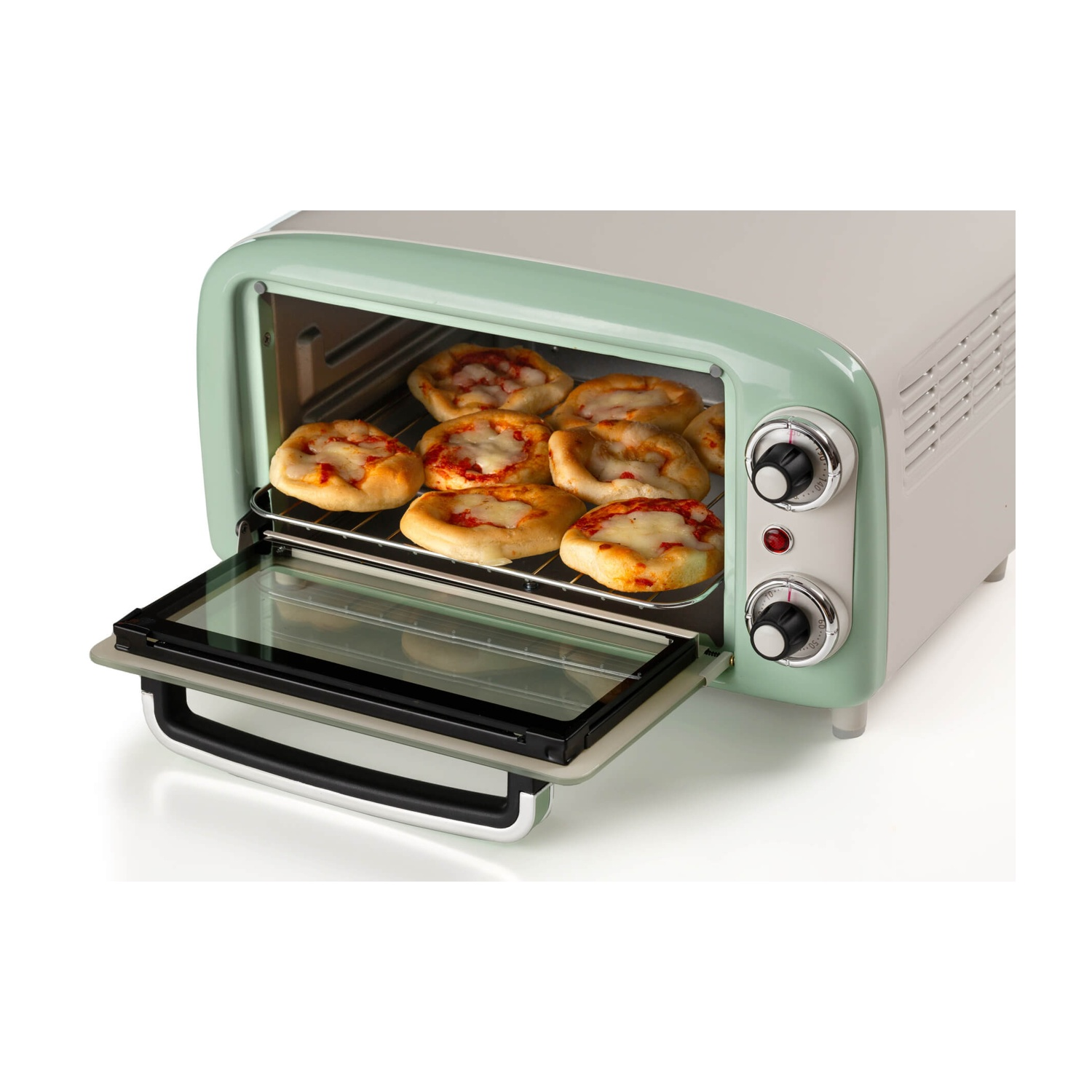 Un forno in stile retrò con piccole pizze all'interno. Il forno è bianco e verde menta. La porta è aperta, rivelando le pizze su una griglia.