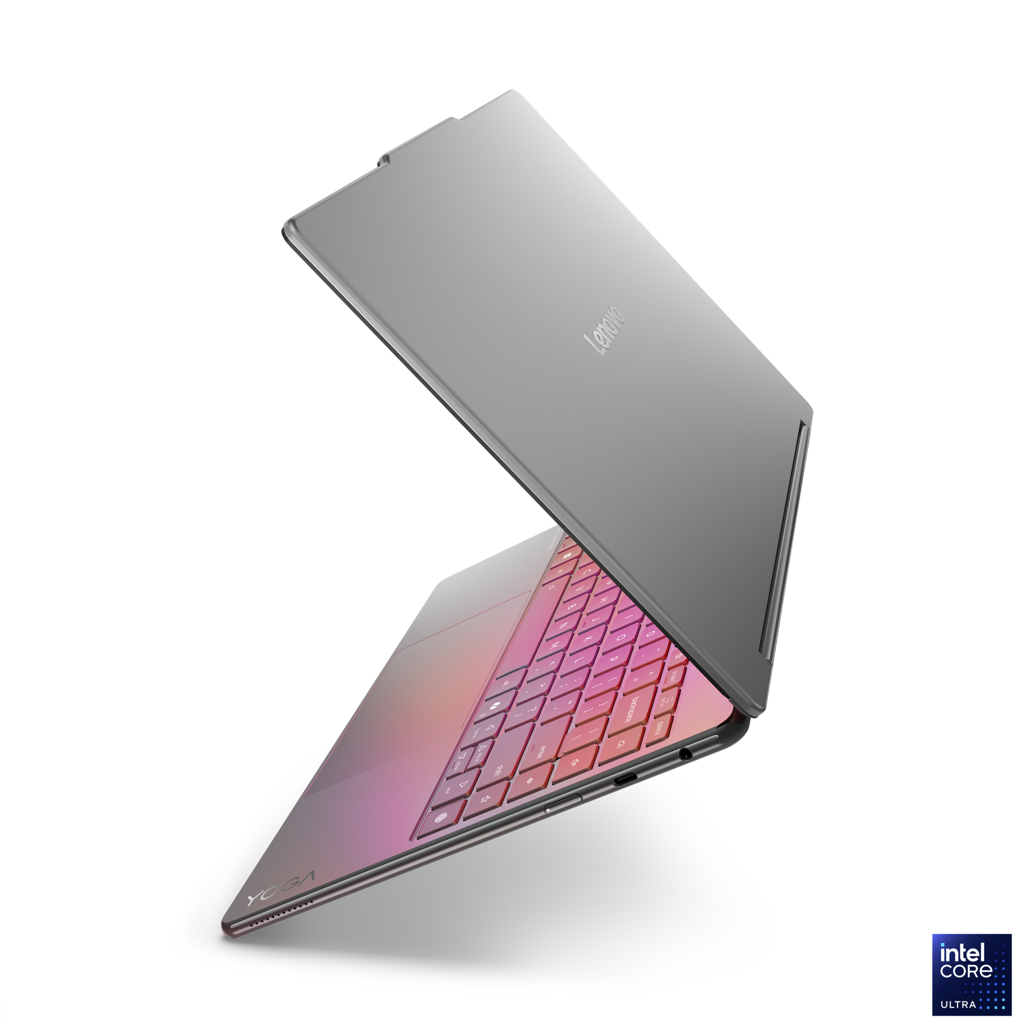 Ein silbernes Lenovo Yoga-Laptop ist geöffnet. Die Tastatur ist rosa und lila. Das Intel Core Ultra-Logo ist in der Ecke.