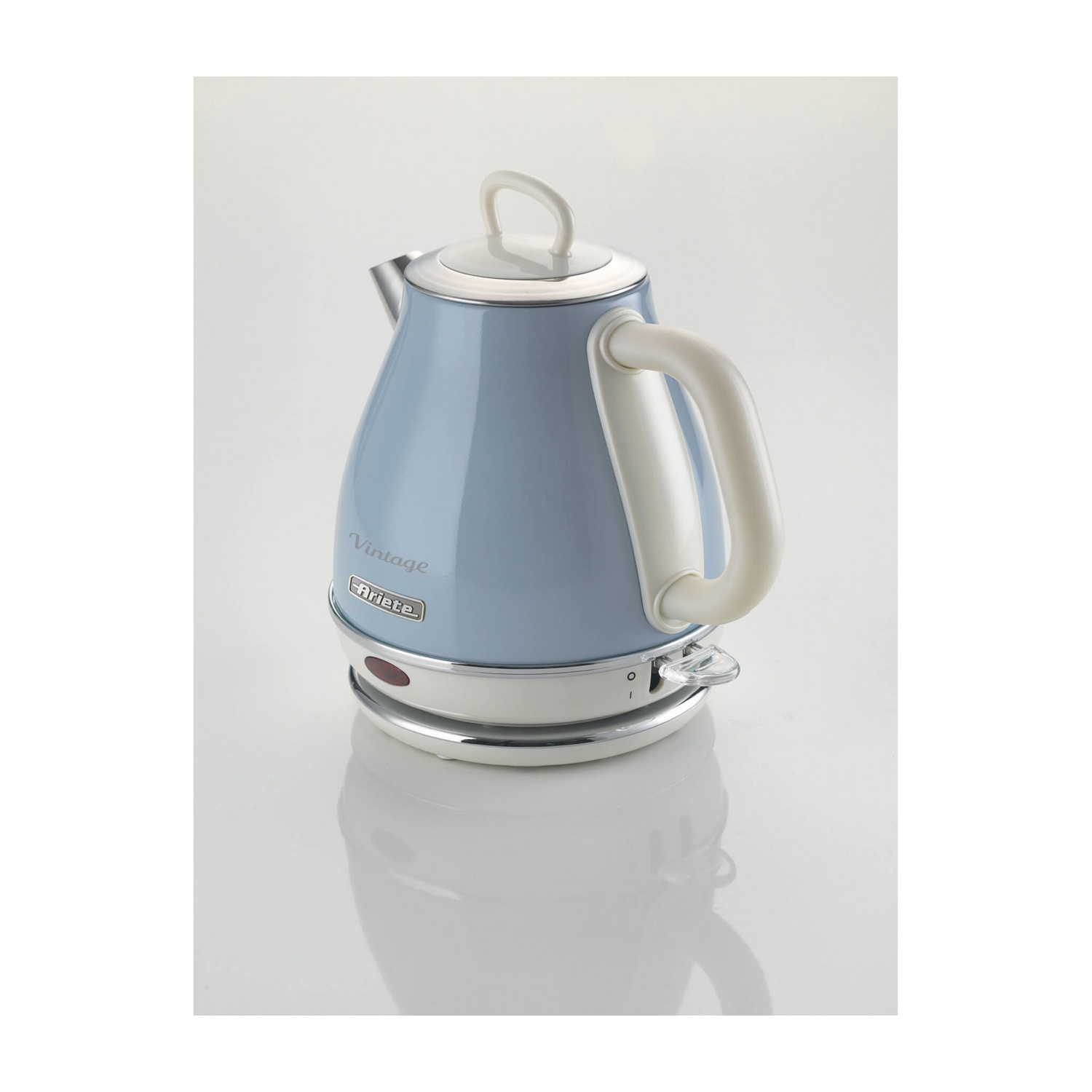 Un bollitore elettrico vintage azzurro con manico e coperchio bianchi, su una superficie bianca con riflesso.
